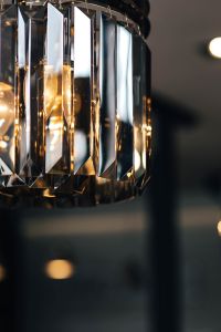 Elegant black designer chandelier with a lit lightbulb