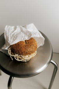 Kaboompics - Pearl Necklace Wrapped Around Sesame Bun on Steel Stool
