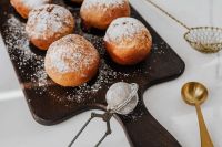 Kaboompics - Powdered Polish Doughnuts on Dark Board with Gold Sifter