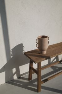 Kaboompics - Sculptural Ceramic Mug on Wooden Bench with Strong Shadows