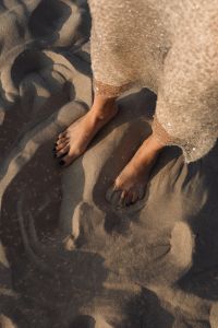 Kaboompics - Top View of Bare Feet and Sequin Dress in Sand