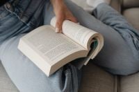 Kaboompics - Hands Holding an Open Book on a Neutral Sofa
