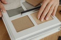 Kaboompics - Hand Touching Textured Beige Sample in Material Catalog