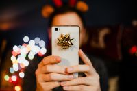 Kaboompics - A handsome man with Christmas presents takes pictures with his phone