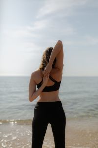 Kaboompics - Woman Stretching in Black Activewear by the Sea