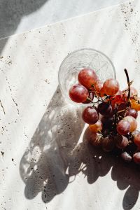 Kaboompics - Top View of Red Grapes in a Faceted Glass on Travertine