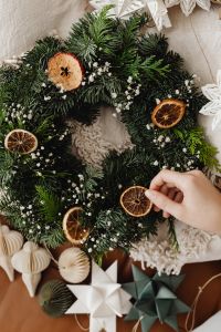 Kaboompics - Hand Placing Dried Orange on Christmas Wreath