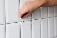 Kaboompics - Laying white ceramic tiles in the bathroom