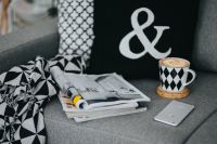 Kaboompics - Patterned Throw, Coffee Cup and Magazines with Smartphone on Gray Sofa