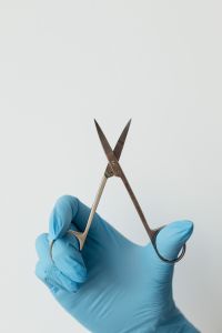 Kaboompics - Dental Surgical Scissors Held in Blue Gloved Hand