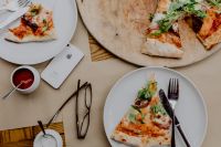 Kaboompics - Overhead Pizza Dinner with Shared Slices and Restaurant Tableware