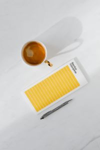 Kaboompics - Top view of a marble desk with coffee, notebooks and pen