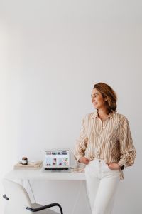 Kaboompics - Smiling Woman in Striped Blouse with Home Office Copy Space