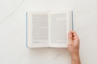 Kaboompics - Hand holding open book on marble table