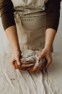 Kaboompics - Woman Holding Fresh Baked Bread in an Apron