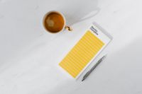 Kaboompics - Top view of a marble desk with coffee, notebooks and pen