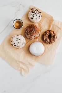 Kaboompics - Powdered and Chocolate-Drizzled Donuts with Espresso on Parchment Copy Space