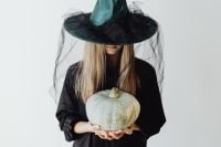 Kaboompics - Woman in Witch Costume Holding a Gray Pumpkin