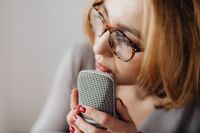 Kaboompics - Woman Whispering into a Silver Microphone for ASMR Voice Recording