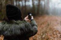 Kaboompics - A woman takes a picture with her iPhone X in the autumn forest