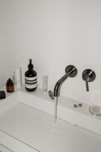 Kaboompics - Wide Flash Photo of White Bathroom Sink with Towel and Beauty Products