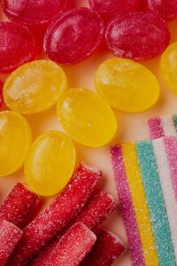Kaboompics - Red and Yellow Jelly Candies with Rainbow Sour Belt, Vertical Macro