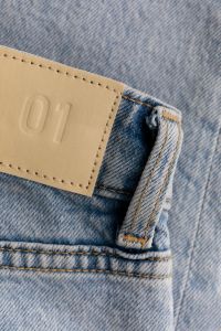 Kaboompics - Embossed 01 Tan Jeans Patch with Belt Loop on Light Wash Denim, Vertical Detail