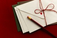 Kaboompics - Love Letter Envelopes with Red String and Pencil on Red Background