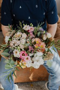 Kaboompics - Close-Up of Pink, White and Peach Mixed Flower Bouquet Held against a Navy Shirt