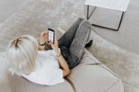 Kaboompics - Woman Reclining on Sofa While Browsing Her Smartphone