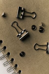 Kaboompics - Black Binder Clips on Textured Notebook Close-Up