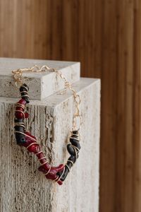 Kaboompics - Red and Black Beaded Necklace on Travertine Blocks