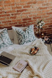 Cozy Bedroom Lifestyle: Breakfast in Bed, Flowers, Coffee and Laptop