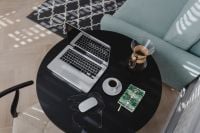Kaboompics - Home Office Flat Lay with Open Laptop, Coffee, Chemex, Phone and Green Notebook on a Round Table