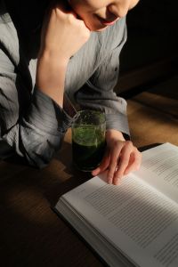 Kaboompics - Woman Reading a Book with a Green Smoothie