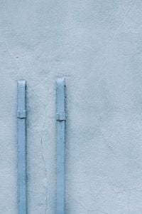 Kaboompics - Pale Blue Wall with Two Vertical Metal Pipes