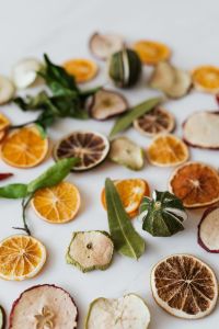 Kaboompics - Blurred Dried Citrus and Apple Slices With Green Leaves