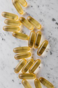 Kaboompics - Scattered Golden Supplement Capsules on Marble