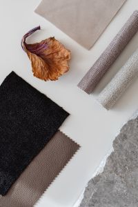 Kaboompics - Rolled Textiles and Dried Leaf on White Surface