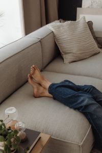 Kaboompics - Close-Up of Relaxing Feet on a Neutral Sofa with a Glass