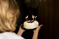 Kaboompics - Rear View of Woman Holding Birthday Cake at a Nostalgic Party