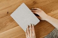 Kaboompics - Woman's Hand Holding a Gray Journal Notebook