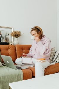 Kaboompics - Woman uses laptop - working from home - reading a book - writing in the planner