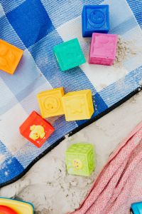 Kaboompics - Bright Toy Blocks on a Blue Gingham Beach Towel for Kids' Summer Content