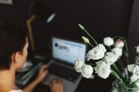 Kaboompics - Woman Working On Laptop With White Flower Bouquet