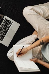 Kaboompics - Laptop and Open Notebook on a Woman’s Lap at Home