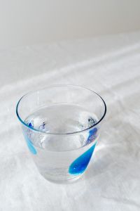 Kaboompics - Overhead Close-Up of Blue Accents Inside a Clear Water Glass, Minimal Hydration Flat Lay