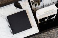 Kaboompics - Black Spiral Notebook and Wooden Bird Decor on Marble in a Minimalist Home Office
