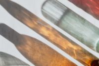 Kaboompics - Abstract Bottle Shadow Pattern in Amber and Sage Glass Tones