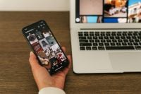 Kaboompics - Hand Browsing Instagram Feed Beside Laptop